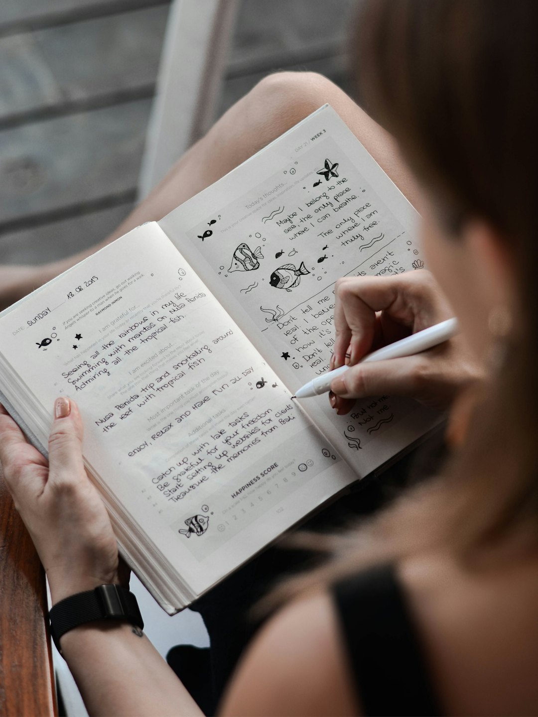 Wanita menulis daftar rasa syukur dan coretan di buku agenda.